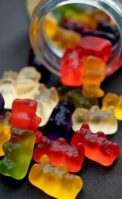 Jar lying on its side, with colorful gummies splurging out